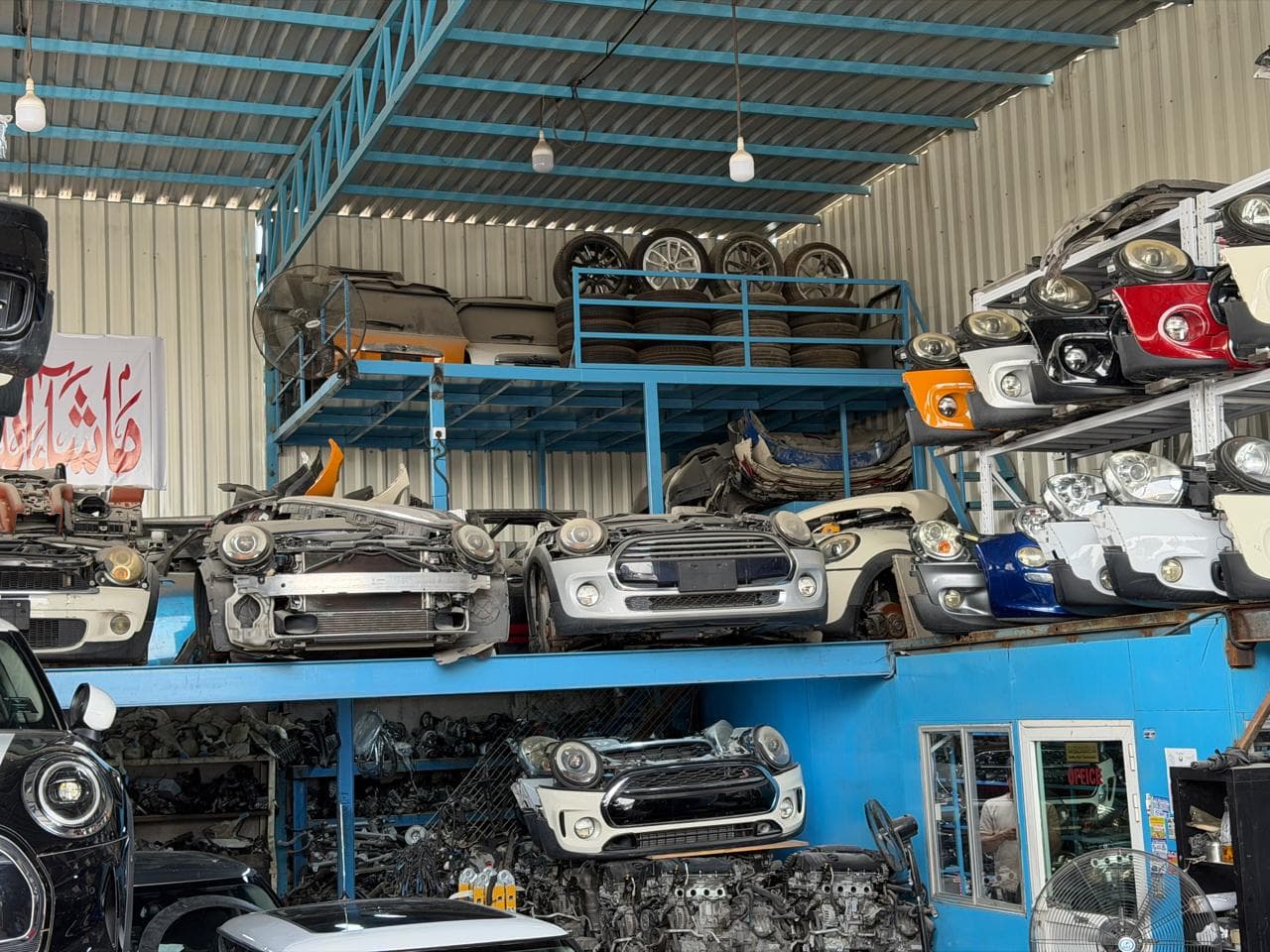 The current inventory bay: wheels on the mezzanine, racks of front bumpers and headlights, engines below