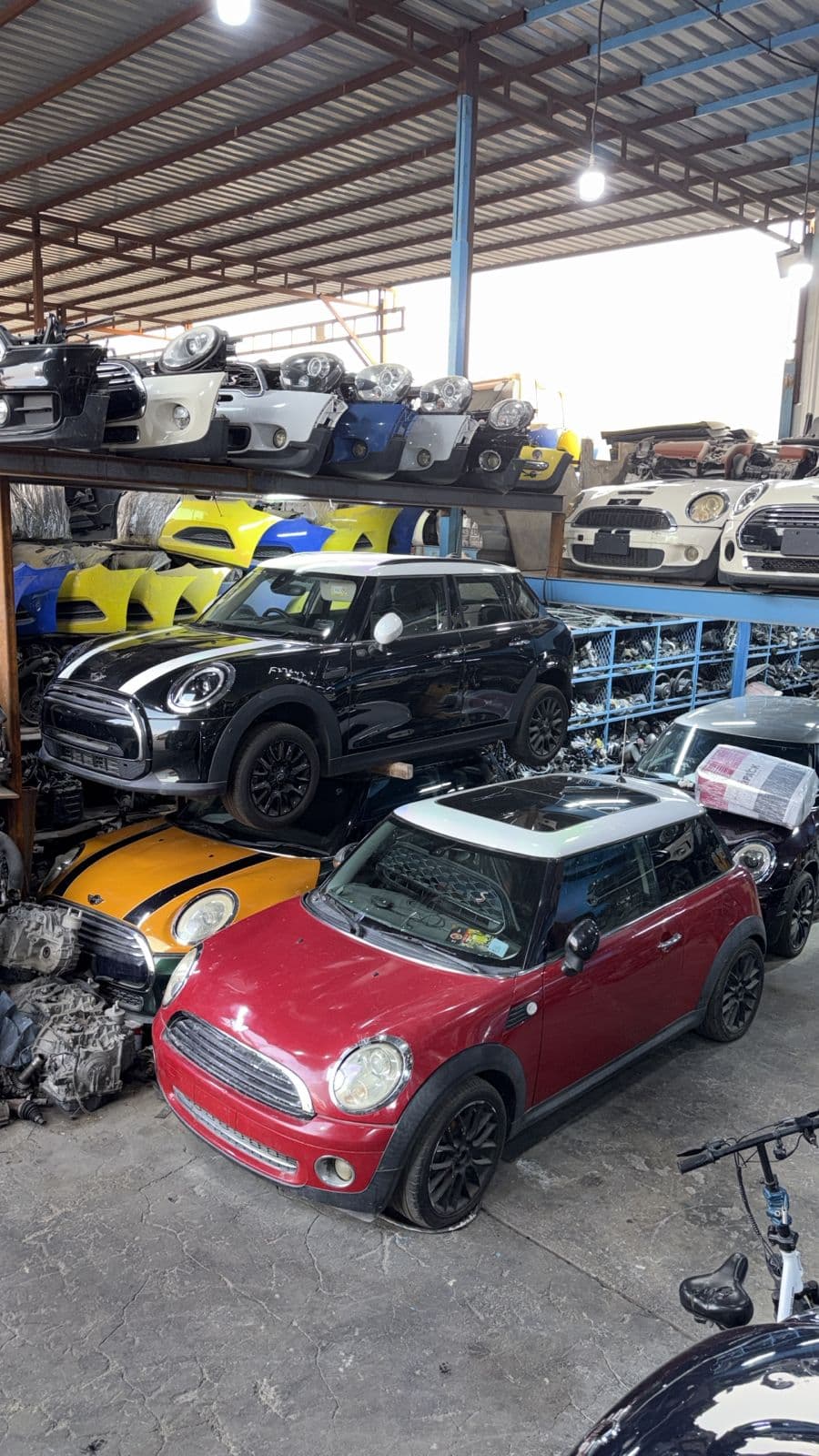 MINI vehicles surrounded by used parts inside the workshop